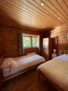 a bedroom with two beds in a log cabin at Beautiful 2 Bedroom Log Cabin With Private Hot Tub - Elm in Leominster