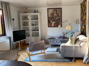 a living room with a couch and a tv at Gelbes Haus bei Mardorf am Steinhuder Meer in Rehburg-Loccum