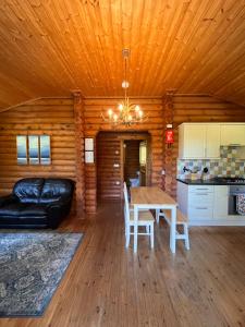 uma sala de estar com uma mesa e um sofá em Beautiful 2 Bedroom Log Cabin With Private Hot Tub - Elm em Leominster