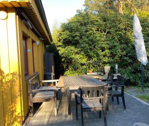 Rehburg-Loccum的住宿－Gelbes Haus bei Mardorf am Steinhuder Meer，庭院配有桌椅和遮阳伞。