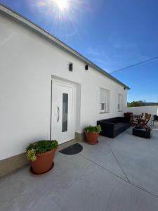 a white building with plants in front of it at PortoSantiago Boutique & Rooms in Portomarin