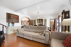 uma sala de estar com um sofá e uma mesa em Vila Portimão T5 com Piscina em Portimão