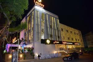 a building with a sign on top of it at night at Layalee Grande Hotel Chennai in Chennai