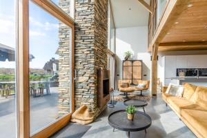 a living room with a fireplace and a stone wall at Buytenplaats Villa 181 in De Koog