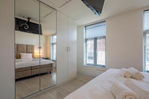 a bedroom with two beds and a mirror at Luxury City Home Alkmaar nearby Amsterdam. in Alkmaar