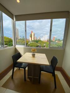 a table and chairs in a room with a large window at Los geranios Villa Sarita Posadas - 3B in Posadas