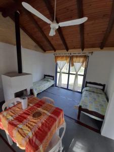 Habitación con 2 camas y ventilador de techo. en Estancia turistica la Providencia, en Termas del Daymán