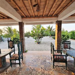 une terrasse avec une table, des chaises et une plage dans l'établissement Casa frente al mar Chevere Beach, à Puebloviejo