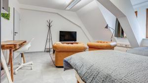a bedroom with a bed and a television and a desk at Pressehaus Apartment Obermarkt Spa in Mühlhausen