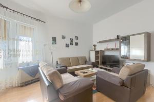 a living room with couches and a flat screen tv at Aida Pula apartment in Pula