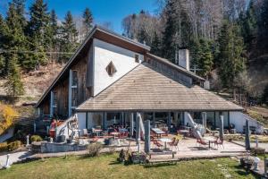 un grande edificio con sedie e tavoli di fronte ad esso di Gîte Le Jorat - Appartement A a Bogève