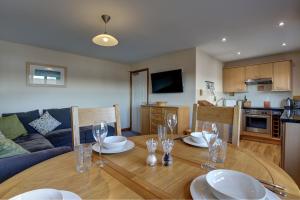a dining room table with plates and wine glasses on it at Bakers Yard in Wells next the Sea