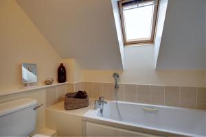 a bathroom with a sink and a toilet and a window at Bakers Yard in Wells next the Sea +17 photos