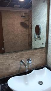 a bathroom with a sink and a mirror at Layalee Grande Hotel Chennai in Chennai