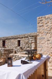 uma mesa em frente a uma parede de pedra com uma mesa de piquenique em Lithos Stone Suites em Areopoli