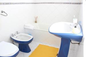 uma casa de banho com um lavatório azul e um WC. em Rich & Poor Hostel Albufeira em Albufeira