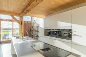 a kitchen with white walls and a wooden ceiling at Buytenplaats Villa 189 in De Koog