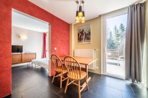 un comedor con mesa y sillas y un dormitorio en Gîte Le Jorat - Appartement B, en Bogève