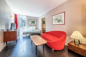 sala de estar con silla roja y mesa en Gîte Le Jorat - Appartement B, en Bogève