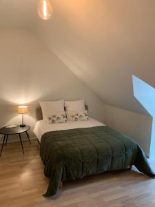 ein Schlafzimmer mit einem Bett und einem Tisch im Dachgeschoss in der Unterkunft Gîte Les Mijoteurs in Rocamadour