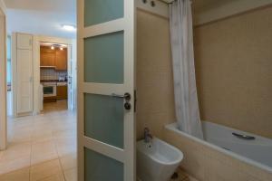 łazienka z drzwiami, toaletą i wanną w obiekcie M&R Apartamento - Swimming Pool - Garage - AC w mieście Puerto de Santiago