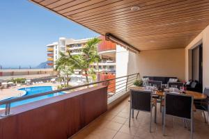 balkon ze stołem i krzesłami oraz basen w obiekcie M&R Apartamento - Swimming Pool - Garage - AC w mieście Puerto de Santiago