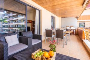 patio z krzesłami i stołem z owocami w obiekcie M&R Apartamento - Swimming Pool - Garage - AC w mieście Puerto de Santiago