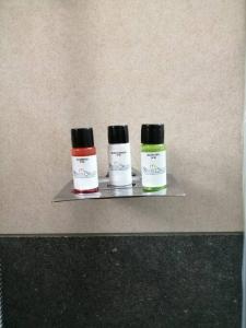 tres botellas de medicamentos sentadas en un estante en The White Orchid Luxury Service Apartments, en Ernakulam