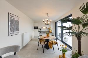 a kitchen and dining room with a table and a plant at Flat Walnes in Diksmuide