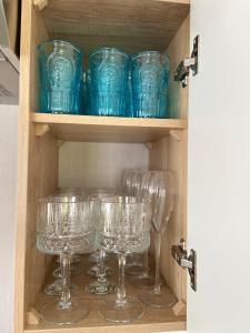 a cupboard with blue glasses in it at The Cornish Hideaway in Poughill