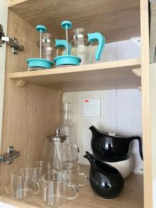 a shelf with glass dishes and bowls on it at The Cornish Hideaway in Poughill