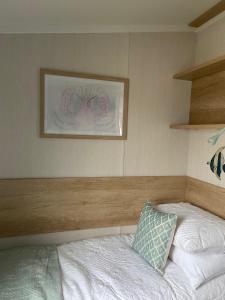 a bedroom with a bed and a picture on the wall at The Cornish Hideaway in Poughill