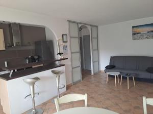 een keuken en een woonkamer met een tafel en stoelen bij Situation idéale au calme et tout confort ! in Mandelieu-la-Napoule