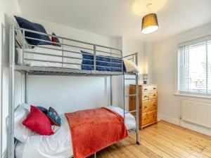 a bedroom with two bunk beds and a dresser at St Mildreds Villa in Ramsgate