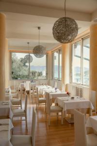 a restaurant with white tables and chairs and windows at Europa Grand Hotel in Lerici