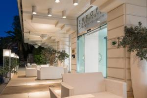 a building with white chairs in front of a store at Europa Grand Hotel in Lerici