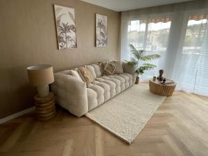 sala de estar con sofá blanco y alfombra en New Cosy Flat Saint Tropez en Saint-Tropez