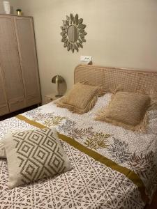 a bed with two pillows and a mirror on the wall at New Cosy Flat Saint Tropez in Saint-Tropez