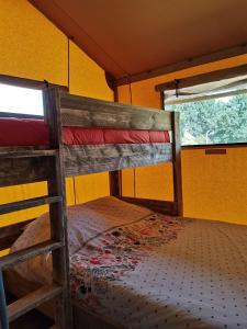 a bunk bed in a room with a window at Tente Lodge 13 couchages in Vaas