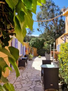 un patio con mesas y sillas en Le Cosy, en Saint-Aygulf