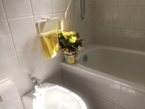 ein Badezimmer mit einem WC und einer Vase aus Blumen in der Unterkunft bilocale Marina di Pisa in Marina di Pisa