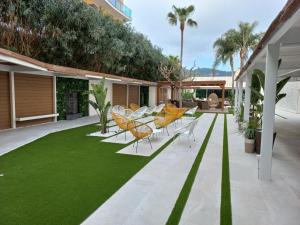 d'une terrasse avec des chaises et une pelouse verdoyante. dans l'établissement Sumus Hotel Monteplaya & SPA 4Sup - Adults Only, à Malgrat de Mar