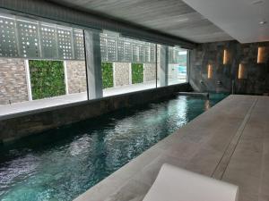 una piscina de agua en una habitación con ventanas en Sumus Hotel Monteplaya & SPA 4Sup - Adults Only, en Malgrat de Mar