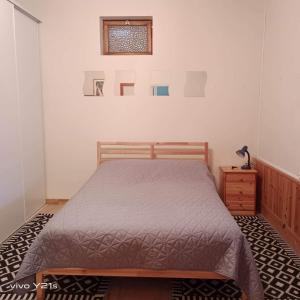 Schlafzimmer mit einem Bett, einem Tisch und einem Fenster in der Unterkunft Petite maison au cœur du village in Nanteuil-en-Vallée