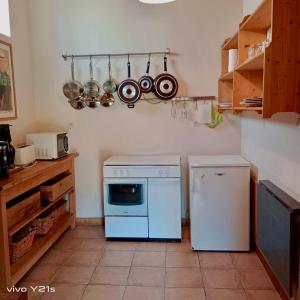eine Küche mit einem weißen Herd und einem Geschirrspüler in der Unterkunft Petite maison au cœur du village in Nanteuil-en-Vallée