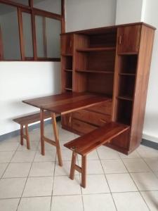 a wooden desk with a bench and a book shelf at Hospedaje Margarita in La Merced