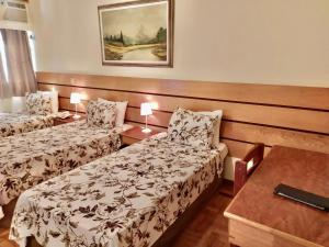 um quarto de hotel com duas camas e uma mesa em Dublin Hotel em São Paulo