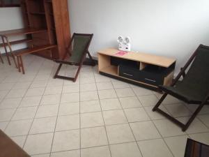 Habitación con 2 sillas, mesa y escritorio. en Hospedaje Margarita en La Merced