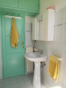 uma casa de banho com um lavatório e uma porta azul em bilocale Marina di Pisa em Marina di Pisa
