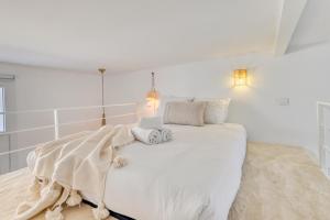 ein weißes Schlafzimmer mit einem großen weißen Bett mit zwei Kissen in der Unterkunft L'Octopus - Petit patio estival in Marseille
